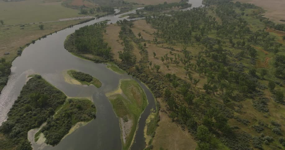 Aerial shot of a winding river in a wooded area