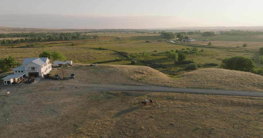 Aerial view of a house on a hill in a farm environment and natural areas on the horizon