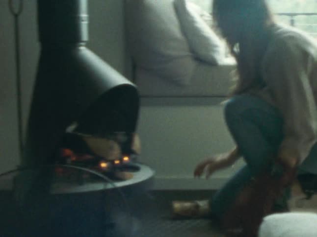 Woman with gloves working on a lit fireplace