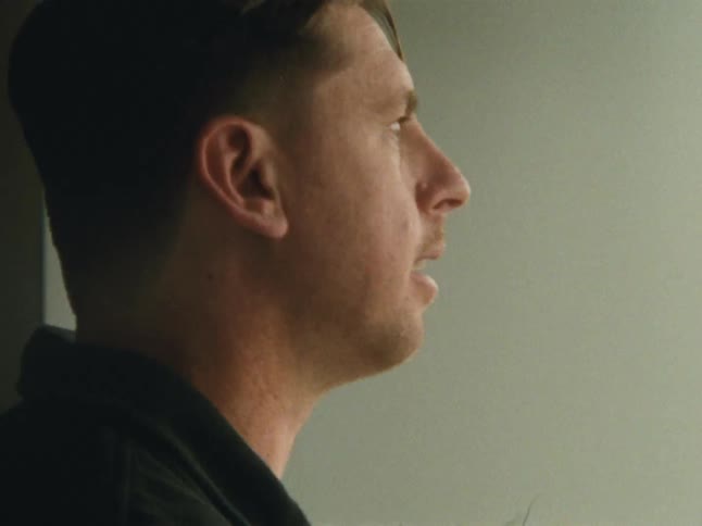 A man and woman drink coffee by the mirror
