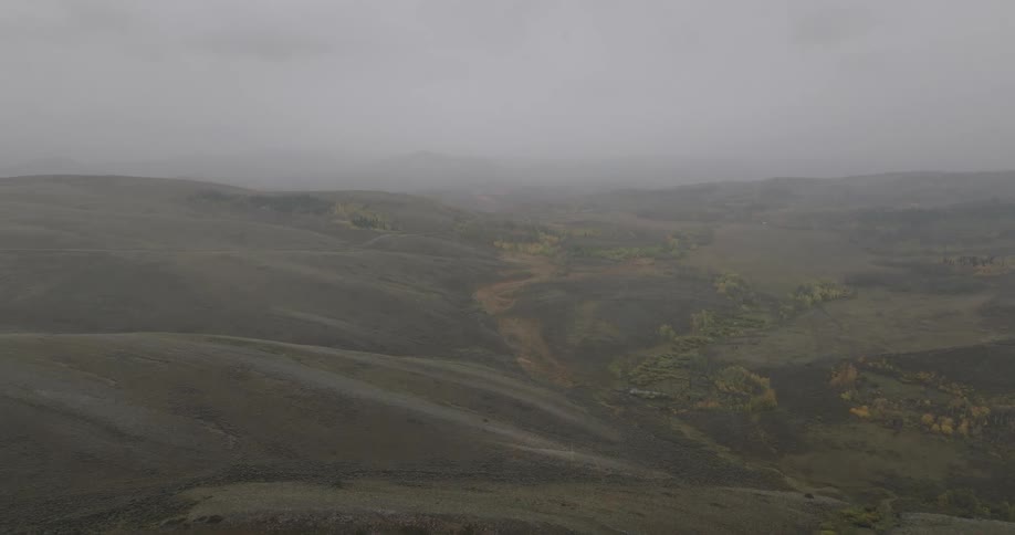 The fog is hanging over the green hills