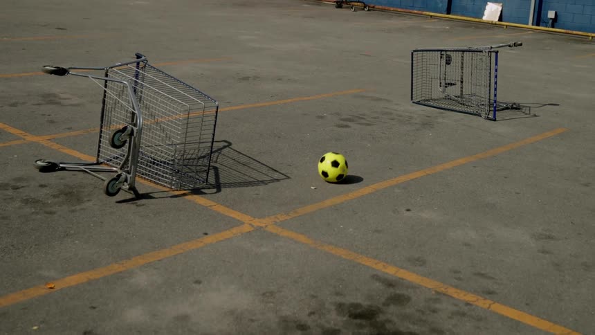 Yellow ball entering a supermarket cart that has fallen on the ground