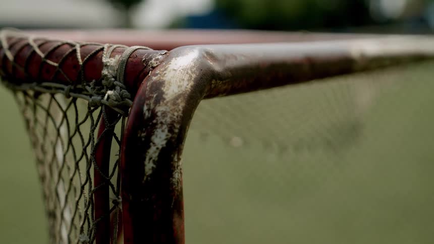 Close up of the corner of a netted goalpost at an outdoor sports venue during daytime