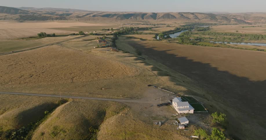 Aerial view of a single house surrounded by flat grassy rural land