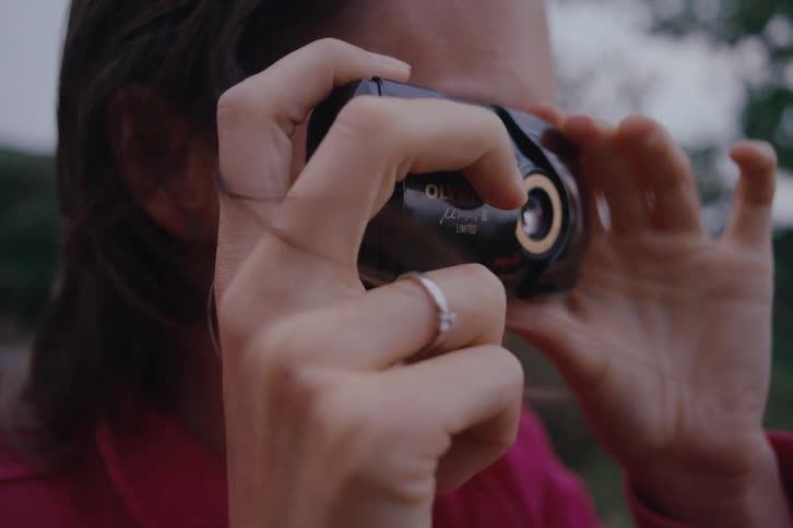 Woman taking pictures with a retro camera outdoors