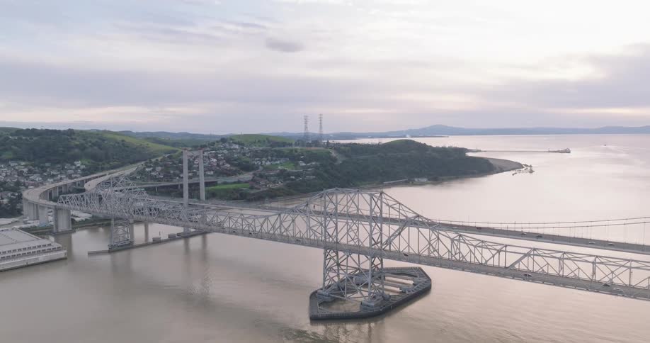 Traffic passes over the bridge towards the neighborhood