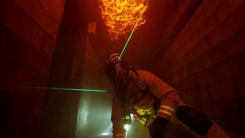 Two firefighters move through the burning home