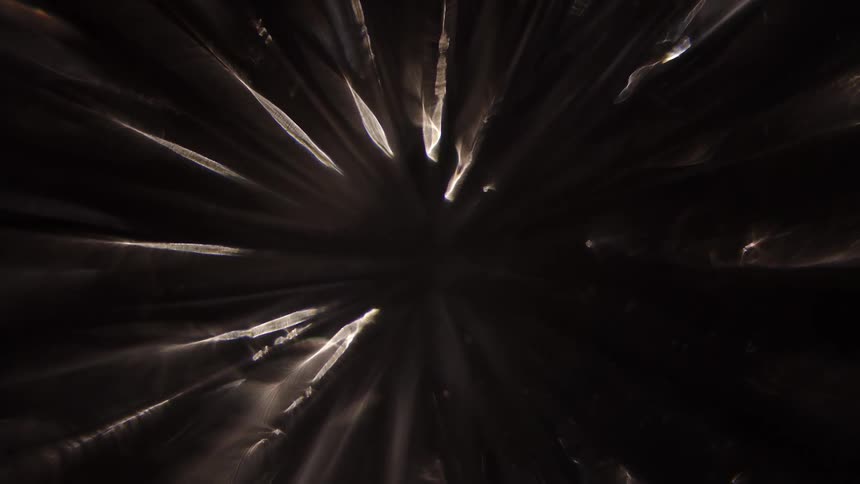 Light shining through to cast thin angular shadows in a cave