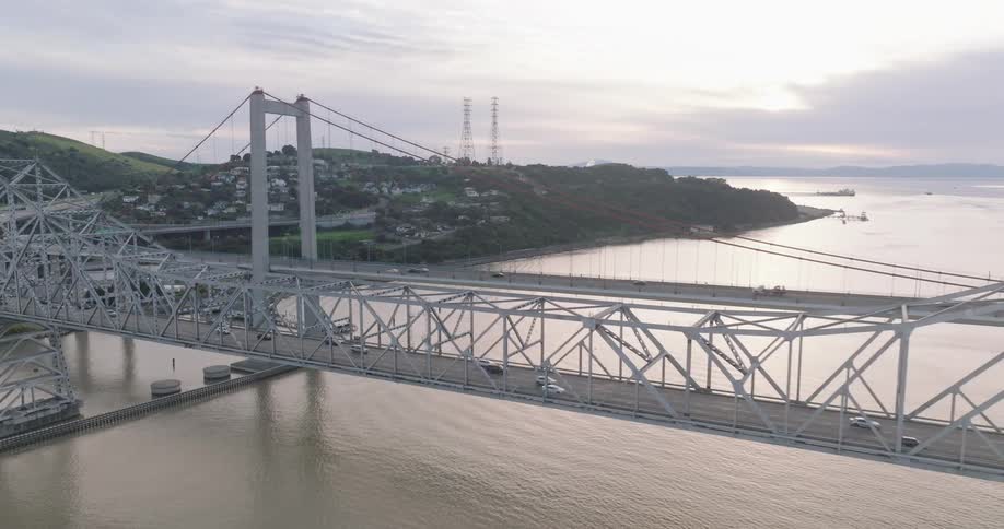 The cars move over the bridge by the coastal town