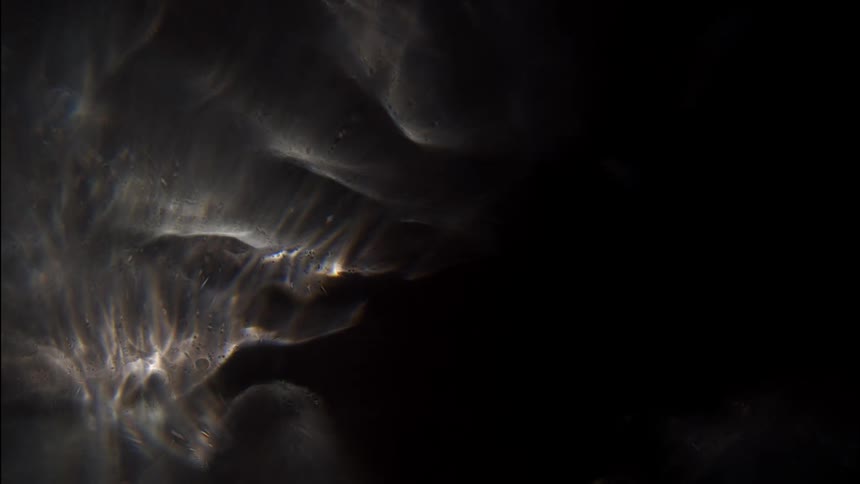 Dense and abstract liquid flowing with a play of light and shadows