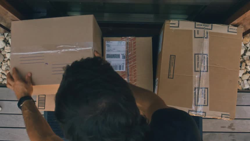 Man leaving delivery boxes on doorstep of a house