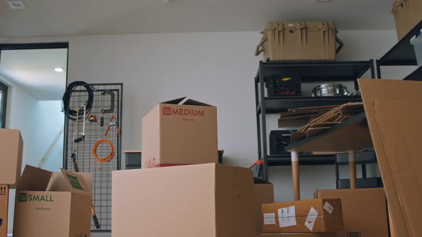 Man and woman stacking boxes inside a room