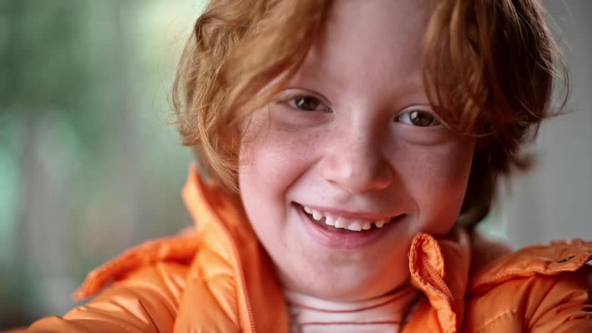 The boy smiles and moves side to side