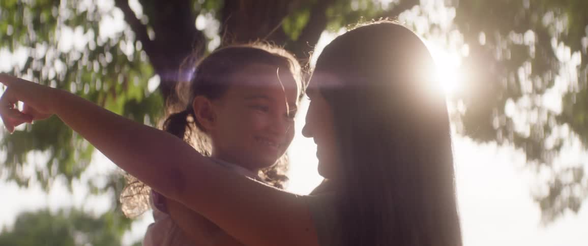 A teenager holds a child in their arms