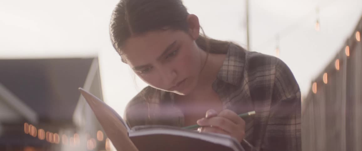 A girl is sketching in her notebook