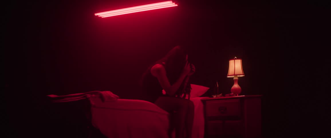 A woman is sad while sitting on her bed