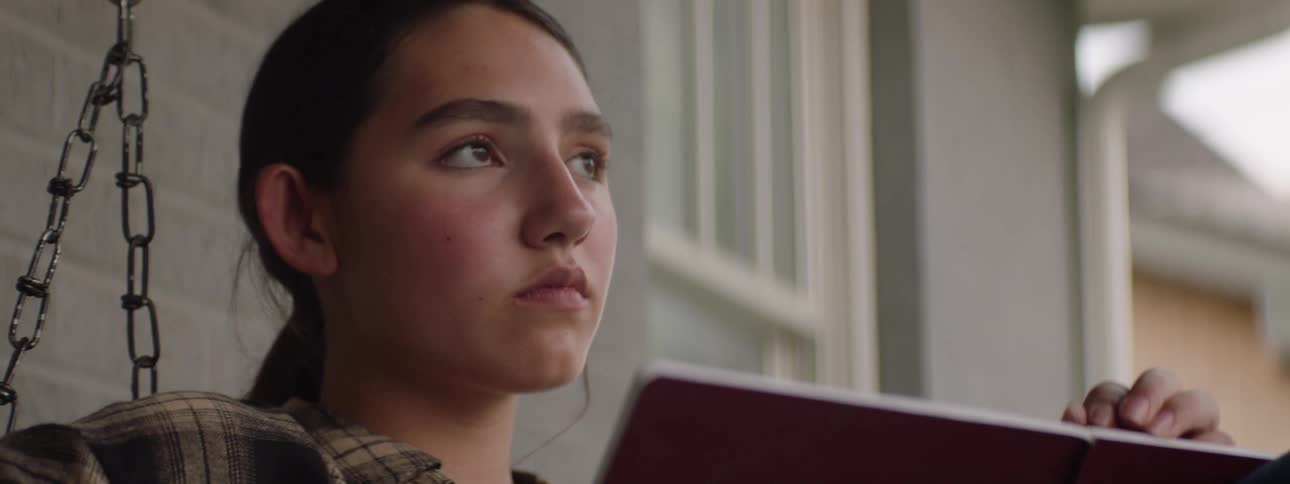 A girl reads a book and closes her eyes