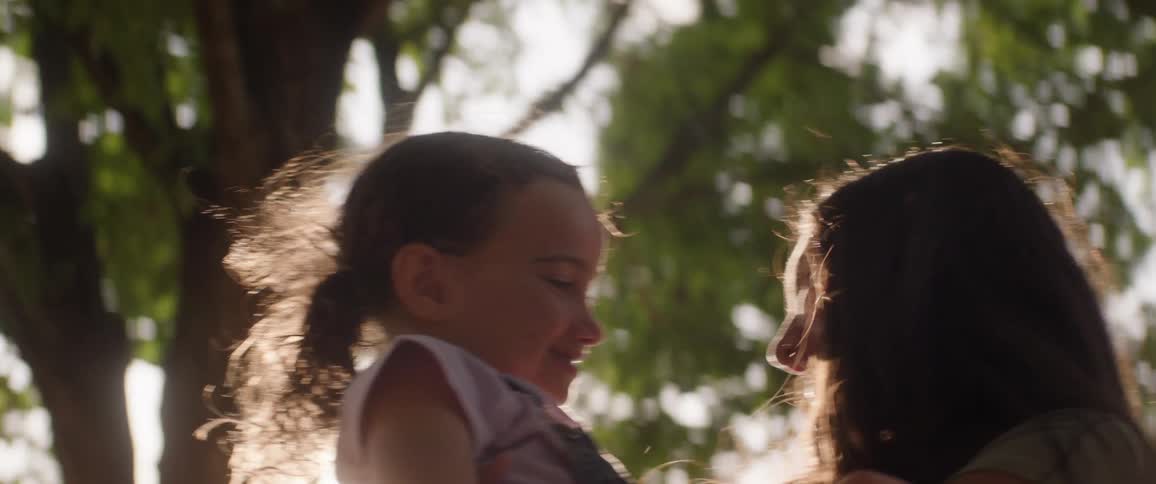 The teenager holds her sister while smiling
