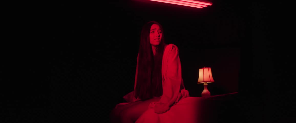 A girl is scared in the dark room with red light