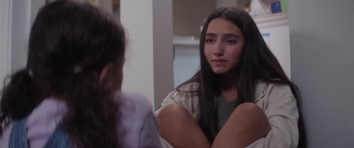 Two girls sit on the floor