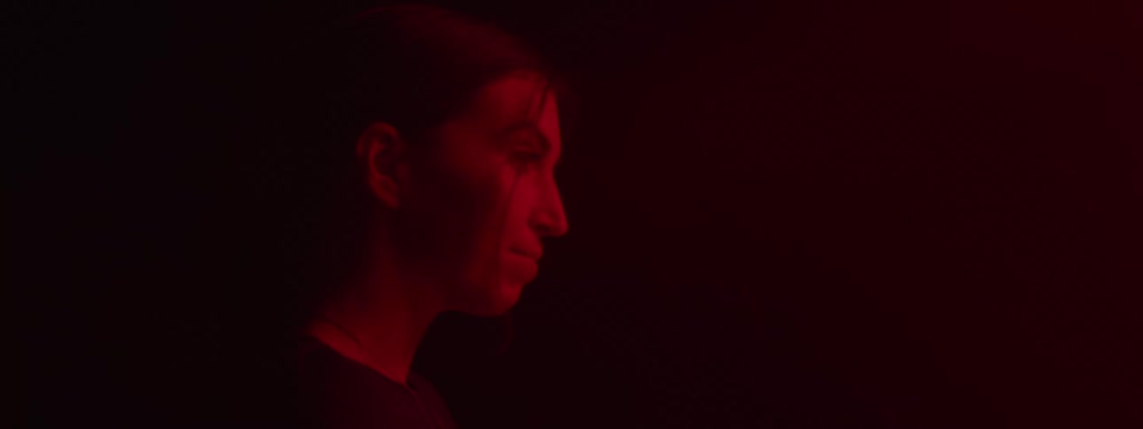 Woman in a dark room with low red lighting