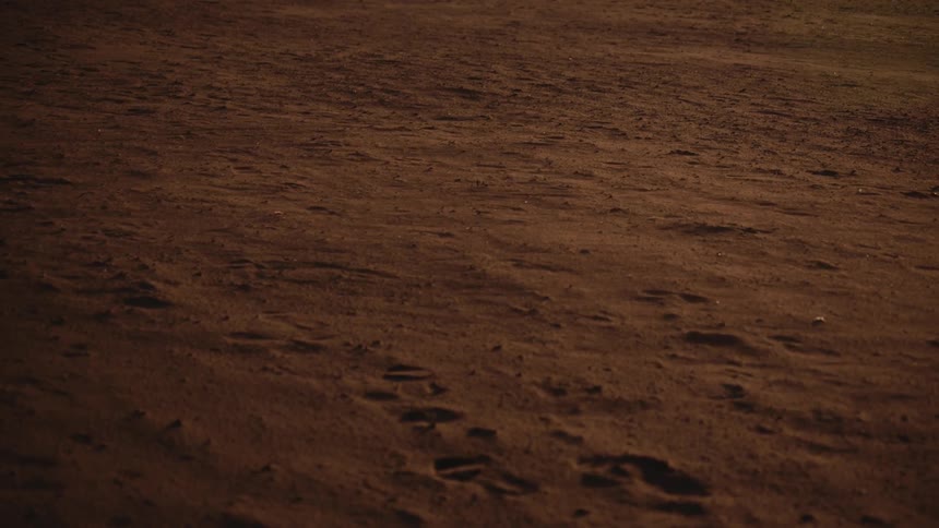 Foot prints lay in the sand on the deserted landscape