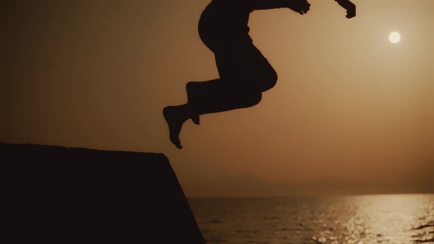 A man jumps into the ocean