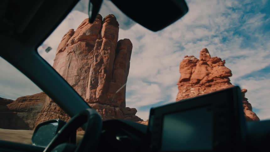 The vehicle is driving by the canyon