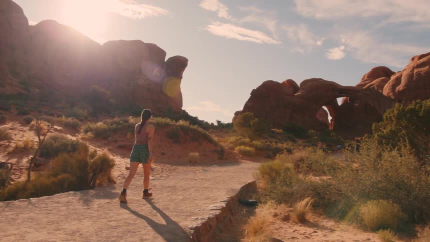 The woman hikes into the canyon on a sunny day