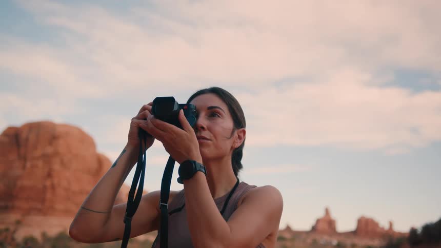 A woman is taking photos of the mountains