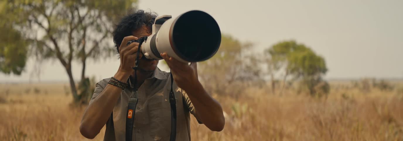 The photographer uses a camera with a very large lens