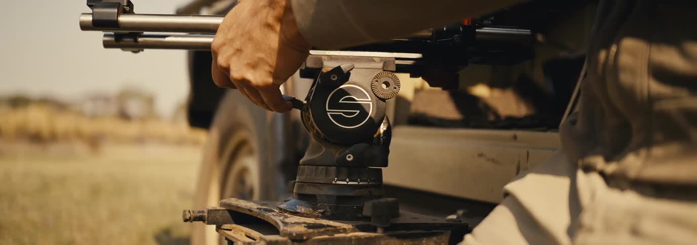 The man adjusts the device by the vehicle