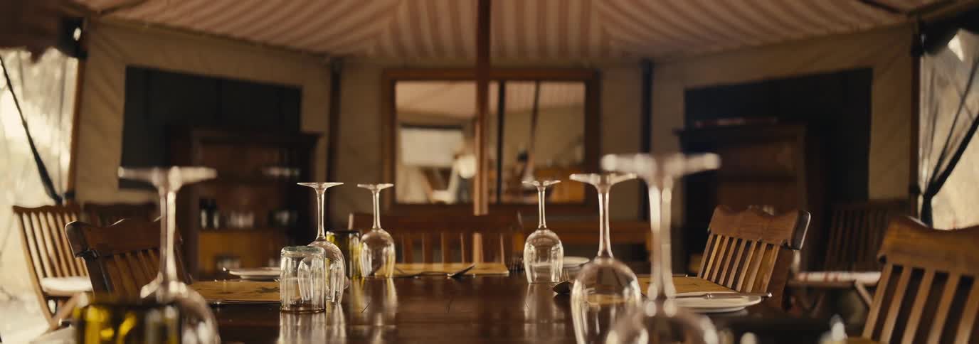 A man is setting the table with glasses