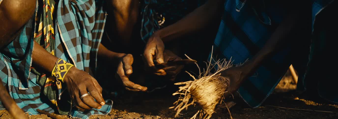 Hands of people from a tribe making fire manually