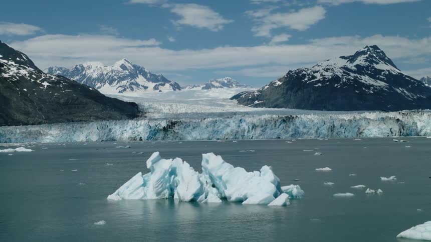 Alaska aerial of Melting ice floating along the arctic coast with mountains in the distance