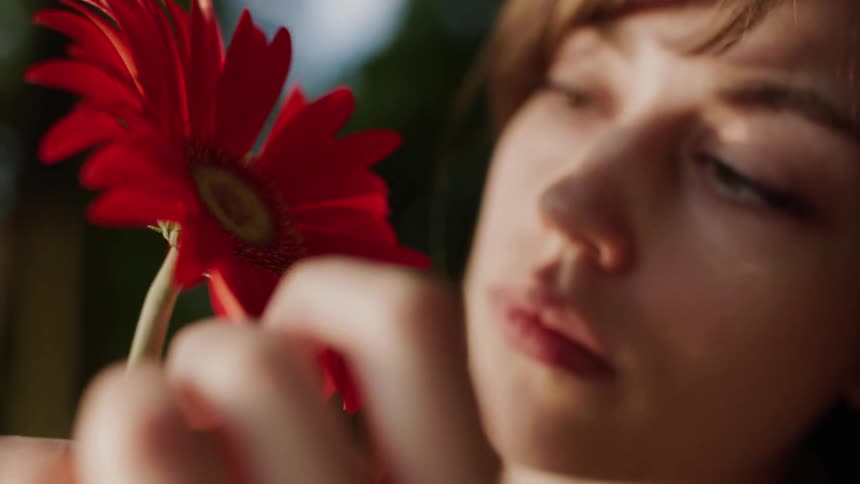 A woman is touching the petals on the flower