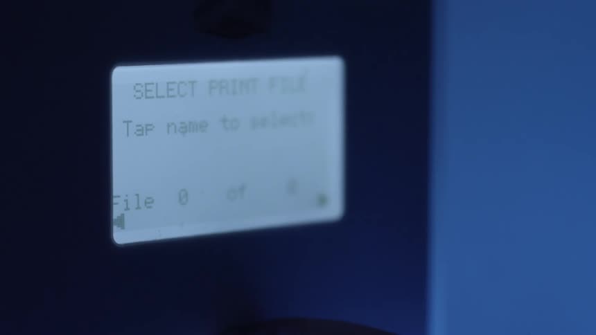 A finger interacts with the illuminated buttons on a touchscreen interface under blue lights