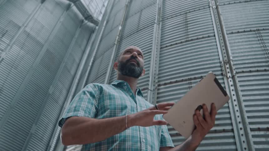 Man in a factory taking notes on an ipad