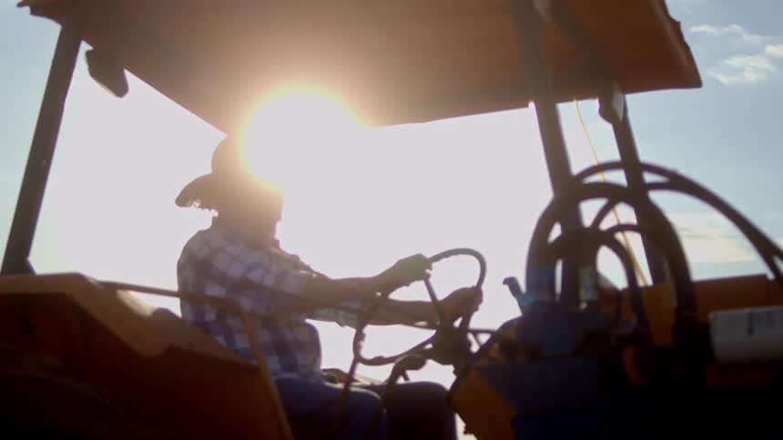 The man is driving the large tractor