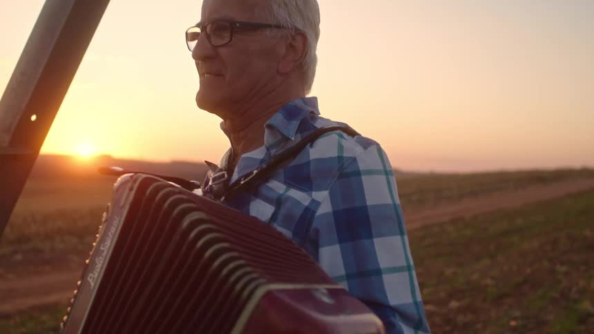 Red sky at morning as the man plays the accordion