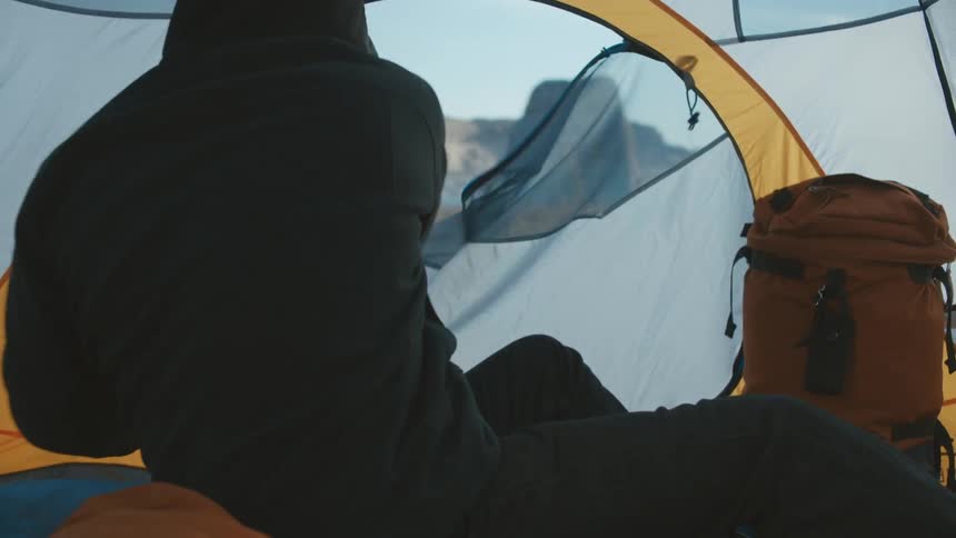 Man waking up in a tent