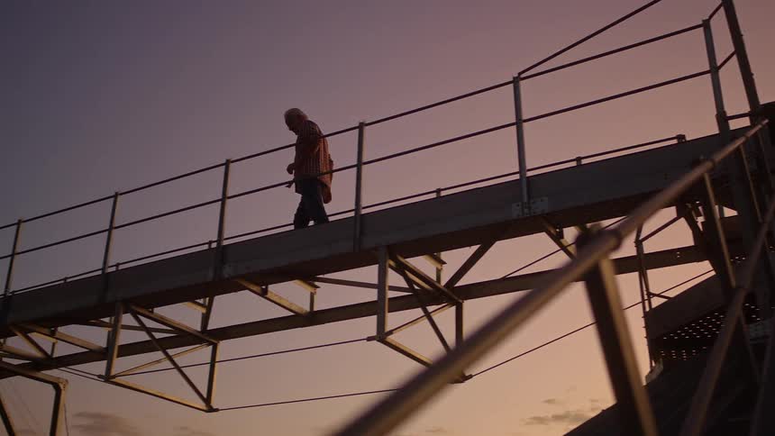 Person walking on a metal platform outdoors
