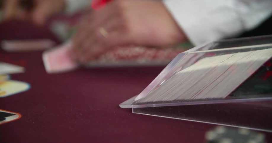 A card dealer deals cards at a table