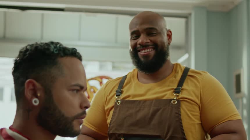 The barber is laughing while holding his razor