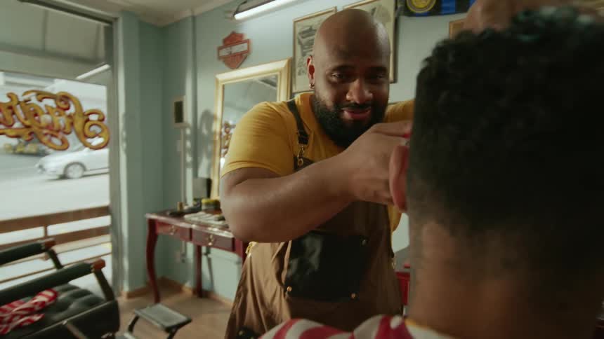 A barber trims a man hair inside a classic barbershop