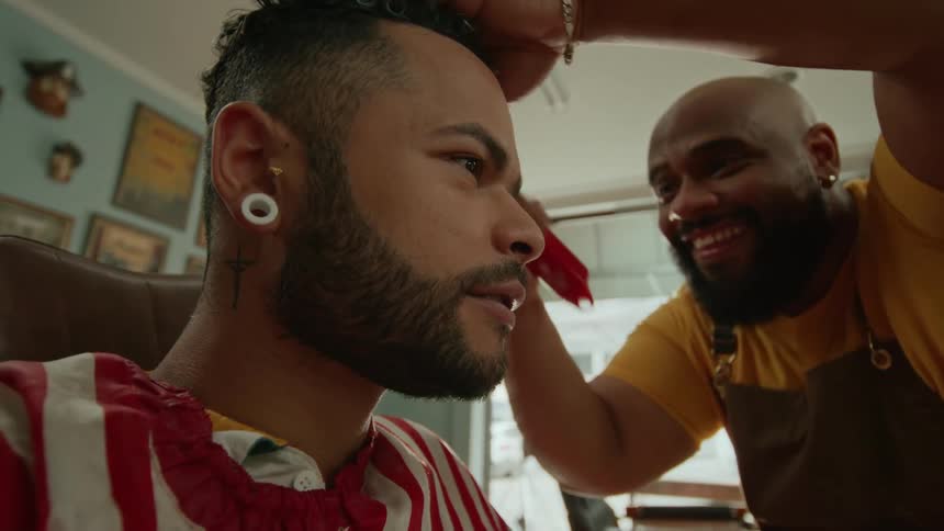 The man uses a razor to shave the mans head