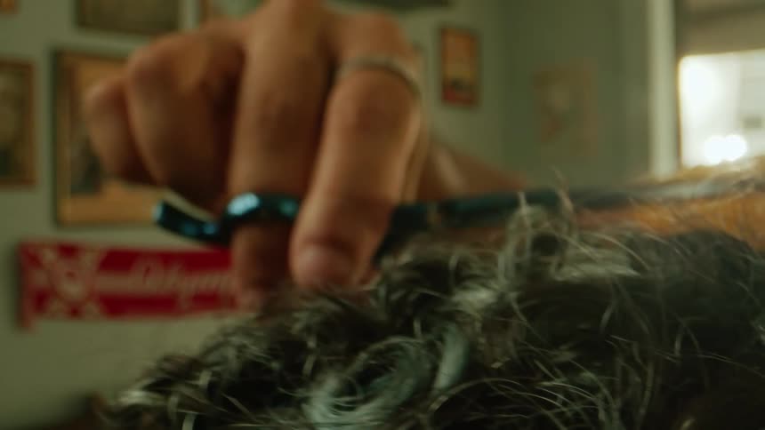 The man is using scissors and a comb to cut the mans hair