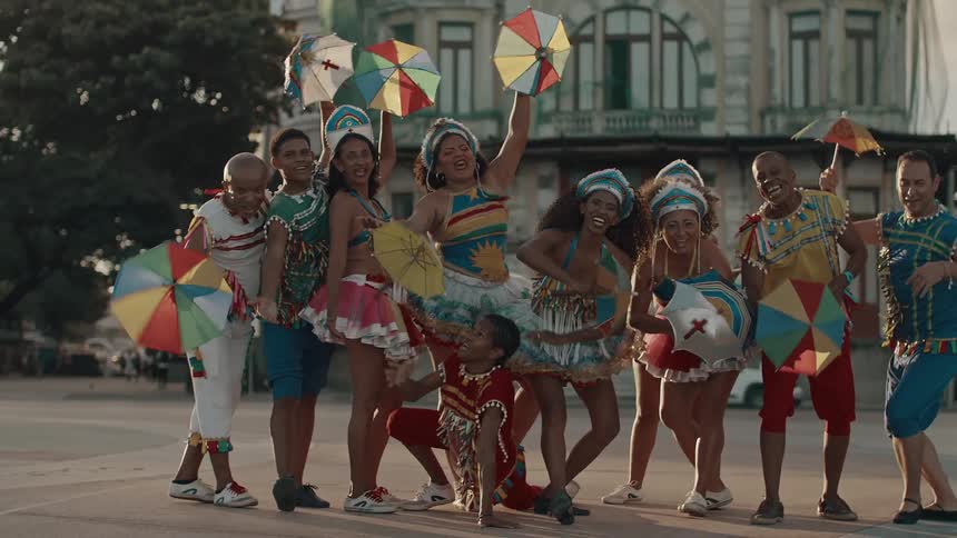 Colorful performers pose with umbrellas in city square