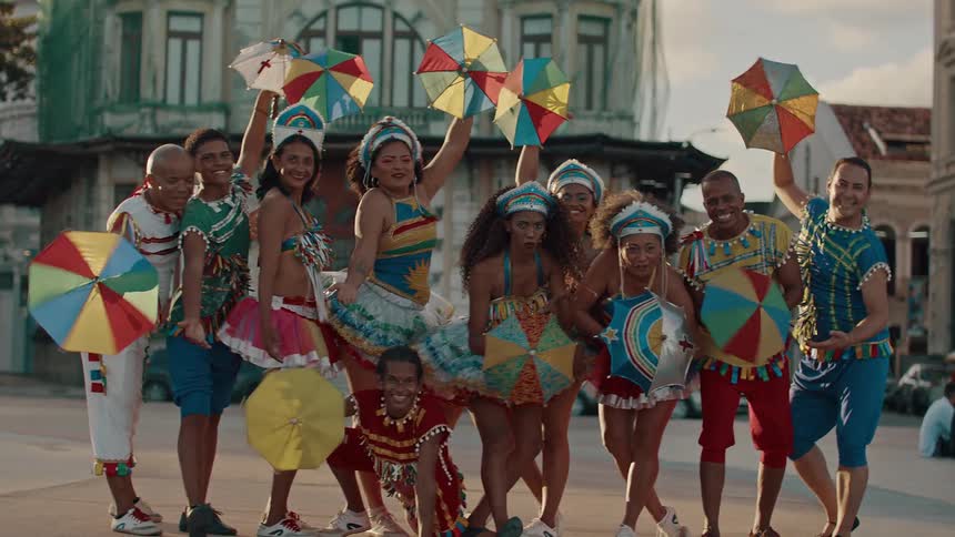 A dance group pose and spin umbrellas