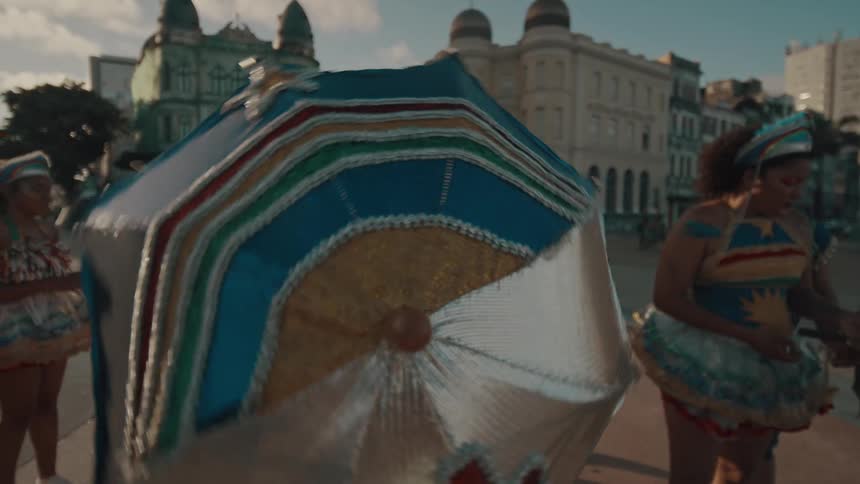 Dancers open their umbrellas and spin them